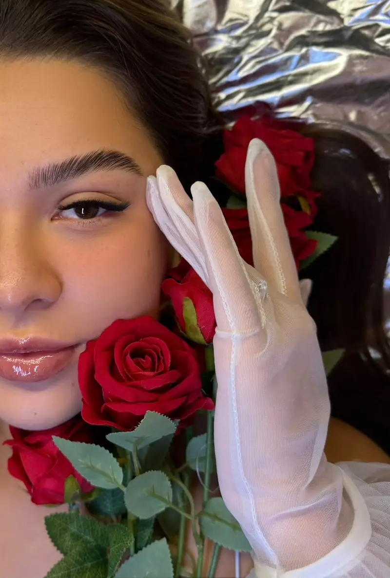 Modelo com rosas vermelhas e luvas, cílios e sobrancelhas — trabalho do Deluca Studio Beauty, Balneário Camboriú